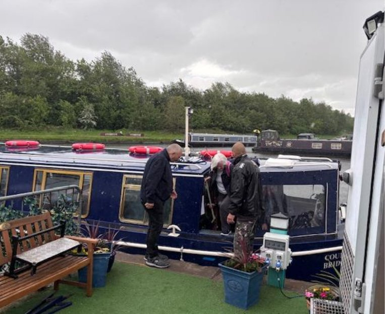 Members stepping off the Countess of Bridgewater narrowboat onto the canal bank under grey skies